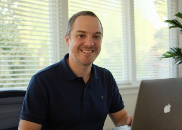 Dutch visual storyteller and digital designer Dirk van Eck working on a MacBook in a bright, modern workspace